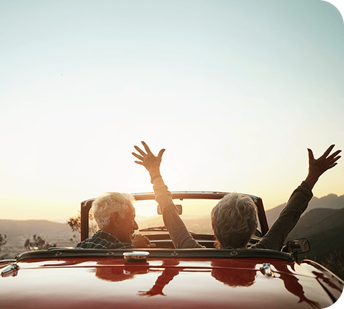 mature-couple-in-convertible-at-sunset