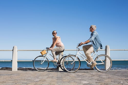 active couple biking near the beach