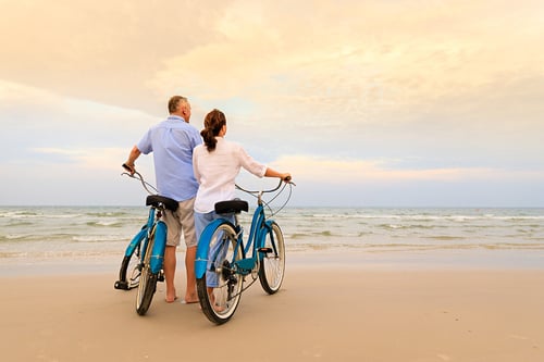 active couple biking on the beach