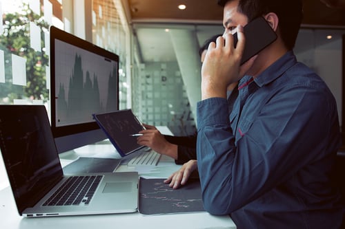 business person taking a phone call while on the computer