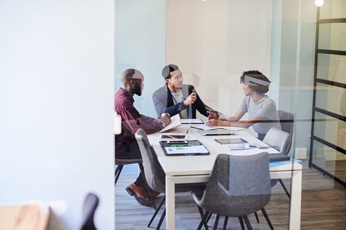 coworkers meeting discussing behind glass