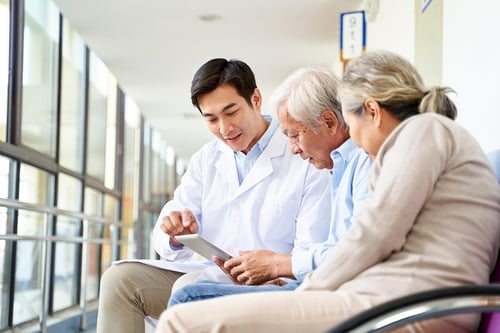 doctor looking at a tablet with his patients