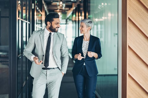 male and female professionals walking and talking