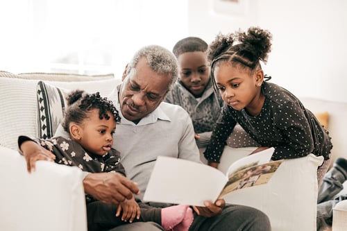 mature man on couch with family multi generation