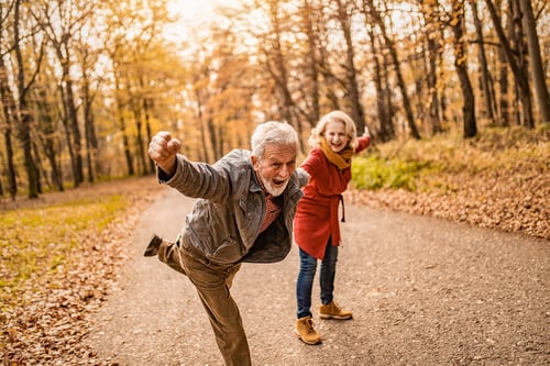 playful active mature couple having fun on a hike in retirement