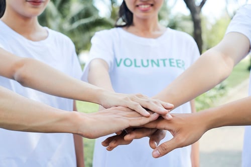 volunteers huddling up joining hands