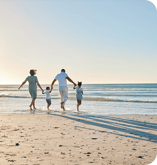family walking on the beach in the water holding hands