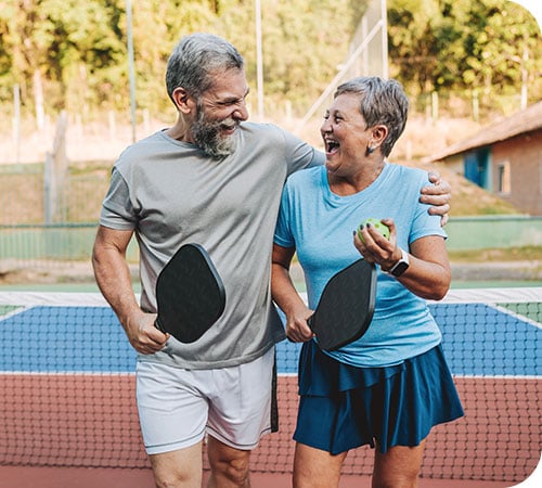 wealth management mature couple playing pickleball