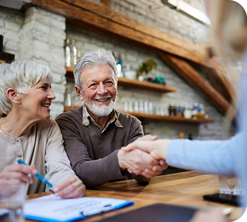 mature-couple-shaking-hands-with-advisor