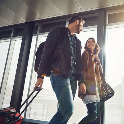 young-couple-traveling-walking-with-suitcases-and-smiling-400x400 young-couple-traveling-walking-with-suitcases-and-smiling-400x400