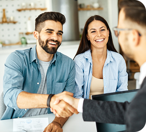 young couple shaking hands with financial advisor